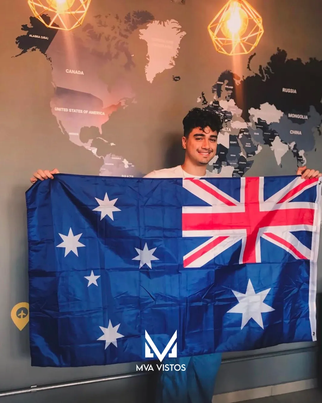 Cliente com a bandeira da Austrália comemorando o visto australiano pela MVA Vistos