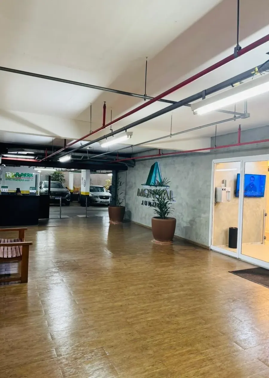 Hall do Edifício Mondial Jundiaí, com recepção, estacionamento e porta automática de acesso